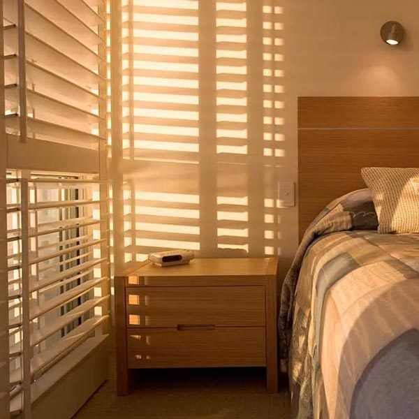 Wood blinds filtering morning light in a Jacksonville bedroom