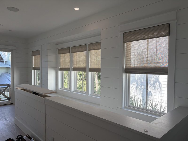Woven wood shades along a shiplap wall