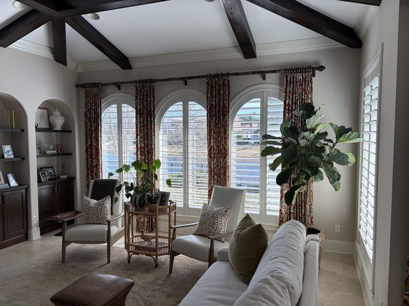 Arched plantation shutters with drapery